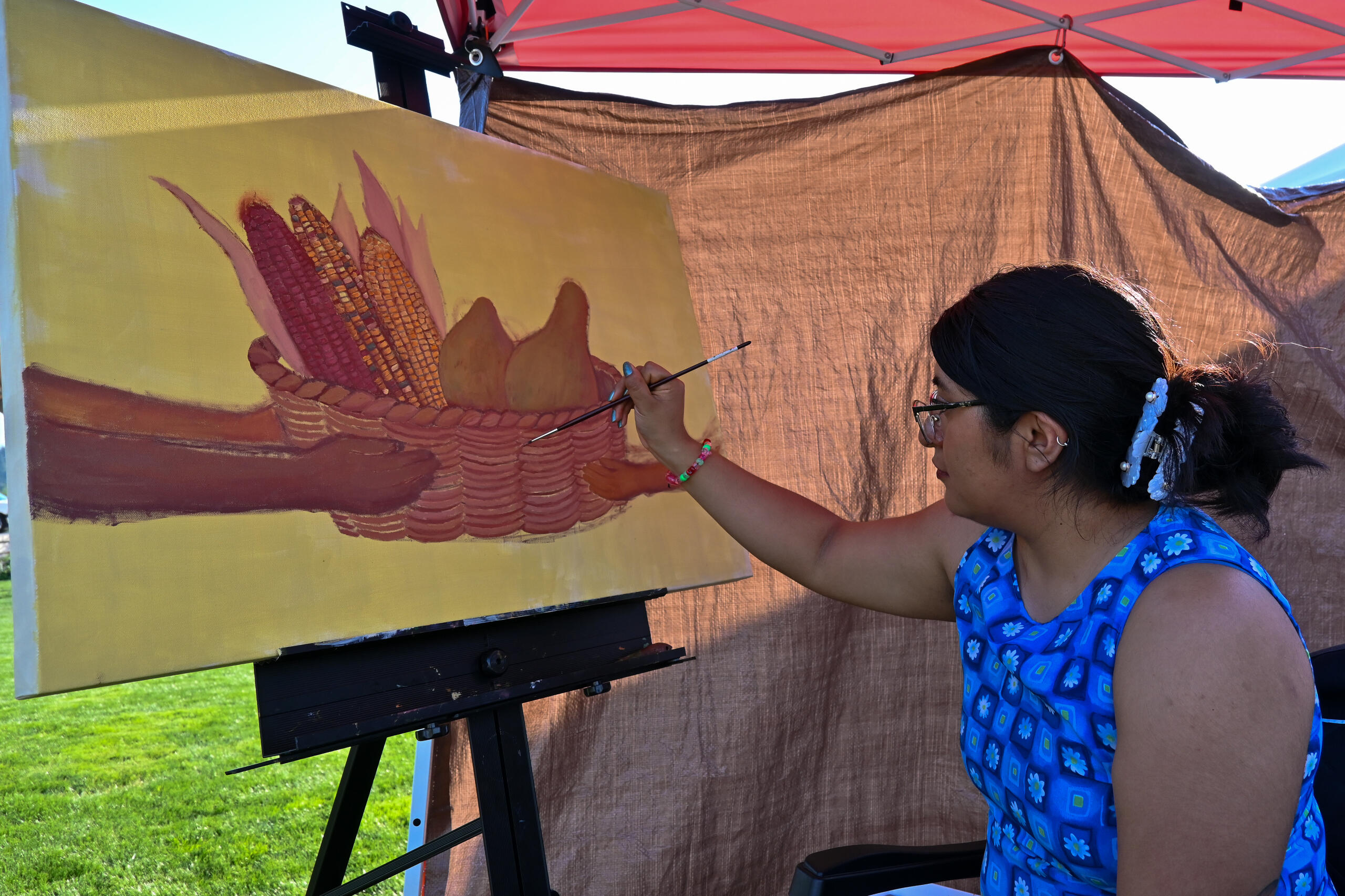 Maricela Xuncax Lazo paints at the Latinos Unidos Siempre Urban Art Fest in Salem, Ore. on Aug. 31, 2024. Photo by Audrey Caro